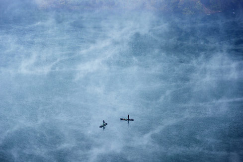 Photos - des pêcheurs pêchent sur un lac enveloppé de brouillard